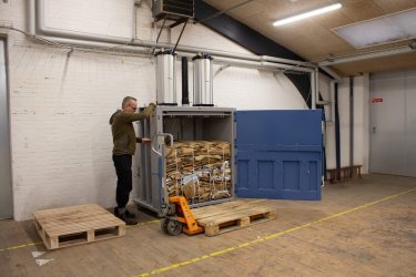 man operating a pneumatic baler
