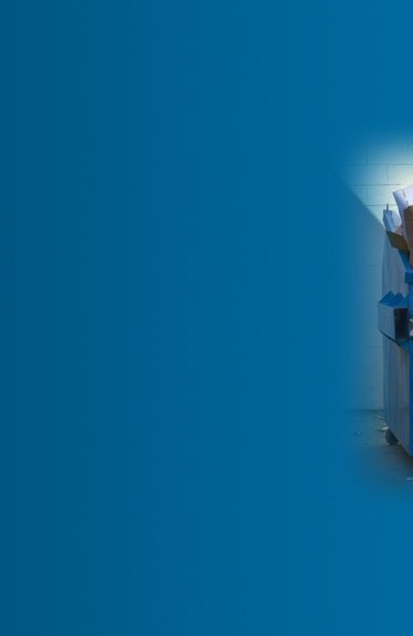 Overfilled cardboard recycling container against a blue background