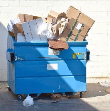 blue container overfilled with cardboard